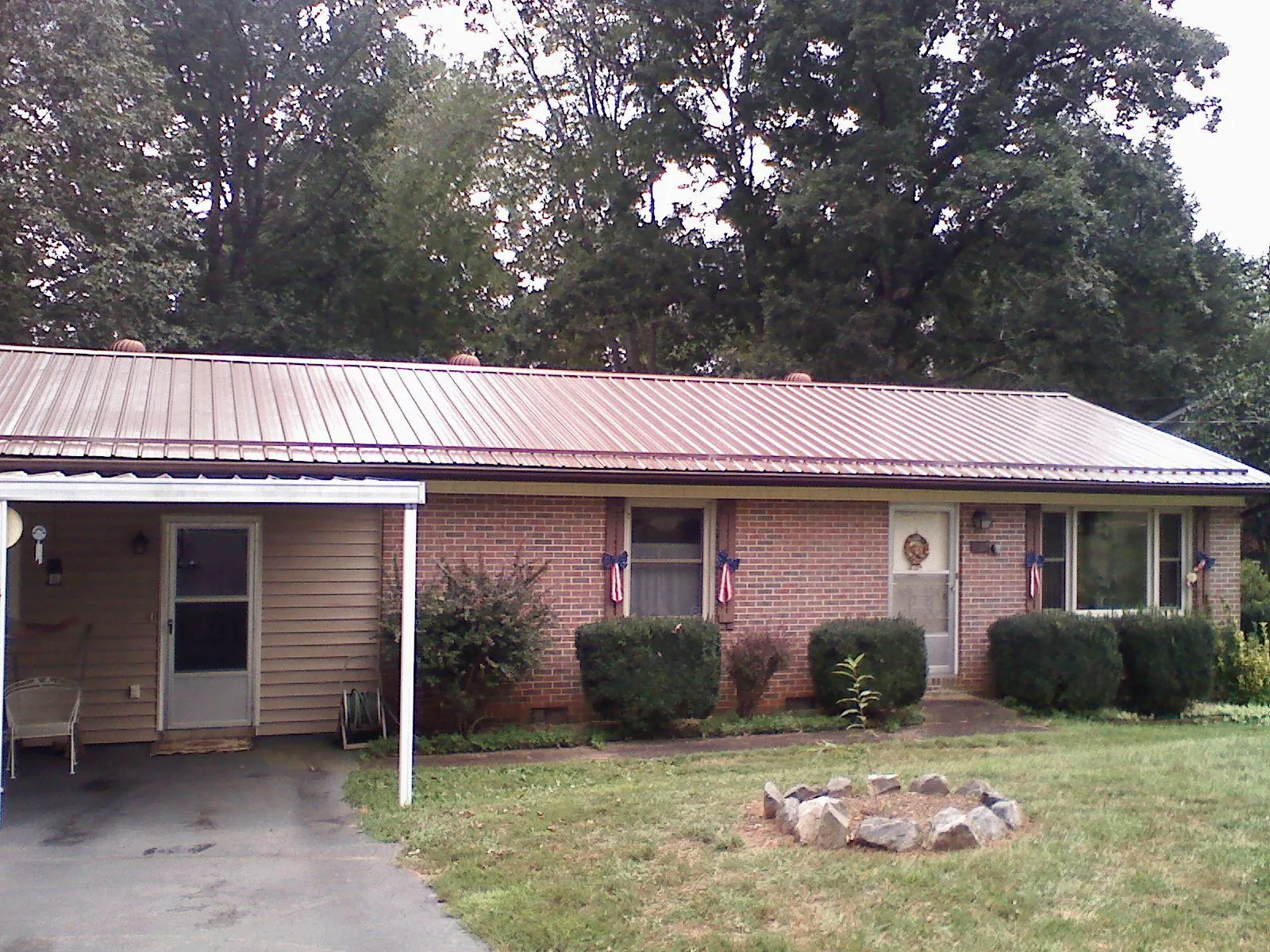 Bronze metal roof and carport on a brick ranch home — Roof Repair work by our crew in Lake Wales